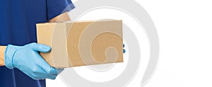 Closeup delivery man hand in medical gloves holding cardboard box isolated on white banner background