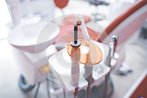 closeup of dental filling polymerization ultraviolet lamp near chair in dentist office