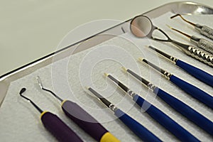 Closeup of dental instruments on a metallic tray on the table