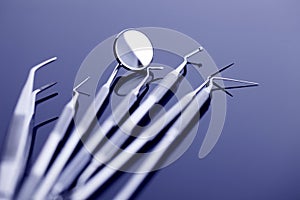 Closeup of dental mirror on glossy background in blue light