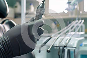 closeup of dentists gloves holding dental drill near chair
