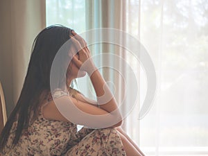 Closeup depressed woman crying while sitting alone on the floor.