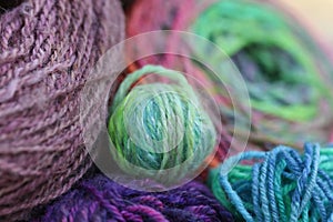 Closeup detail of colourful hand spun sheep wool merino fibres, rolled up in a yarn ball skein.