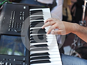 Closeup detail of a hand playing on piano keyboard