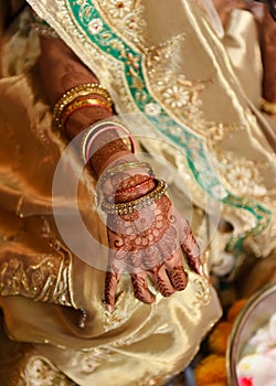 Closeup detail of an Indian bride wearing beautiful colorful garments and henna tatto