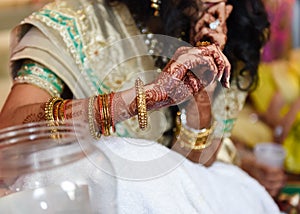 Closeup detail of an Indian bride wearing beautiful colorful garments and henna tattoo