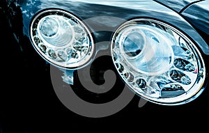 Closeup detail of LED headlight luxury car. Beautiful modern elegance headlamp car. Black automobile. Automotive industry