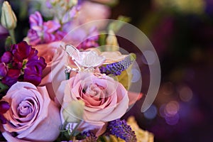 Closeup detail of purple wedding bouquet with butterfly pin