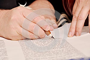 Closeup detail of a Rabbi writing a Torah manuscript scroll