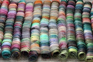Closeup detail of rolags of sheep wool and fibres ready for spinning on a handspindle or a traditional spinning wheel.