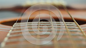 Closeup detail of steel guitar strings and frets for making music. Guitar neck in selective focus.