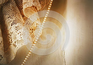 Closeup detail of vintage satin and lace wedding dress with a strand of tiny pearls