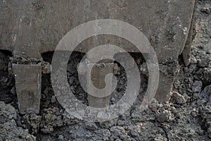 Closeup dirty bucket of backhoe working at construction site. Bucket teeth of backhoe digging soil. Crawler excavator digging on