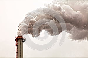 Closeup of dirty dark smoke clouds from a high industrial chimney