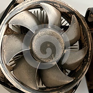 Closeup of a dirty metal computer fan on a white surface