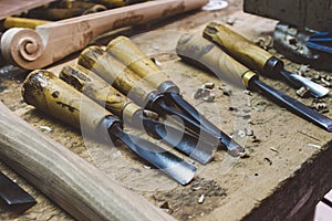 Closeup of dirty wood carving tools on the table under the lights