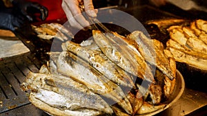 Closeup of dish full of roasted grilled fish. Cooking famous Turkish dish Balik Ekmek on street