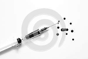 Closeup of a disposable syringe and many blood drops isolated on white black and white