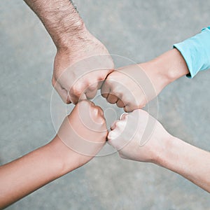 Closeup of diverse group of people from above making fists in a circle to express unity, support and solidarity. Hands