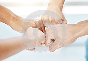 Closeup of diverse group of people making fists in a circle to express unity, support and solidarity. Hands of