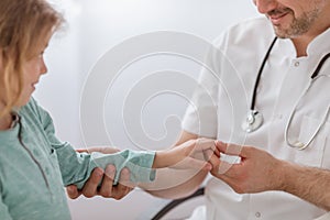 Closeup of doctor checking hand of child in the hospital