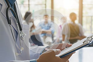 closeup doctor with stethoscope, patients are on background