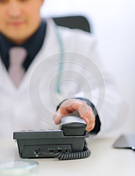 Closeup on doctors hand taking phone handset