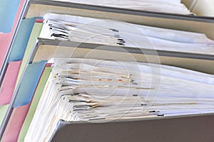 Closeup of document binders with papers and tabs