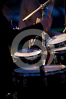 Closeup of drummer playing drums at concert.