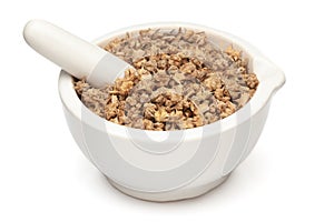 Closeup of Dry gokhuru fruits, in white ceramic mortar and pestle.