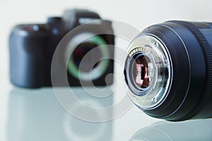 Closeup Of DSLR Photo Camera And Still Lens On Desk