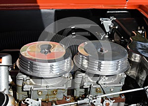 Closeup of dual carburetors on an automobile engine