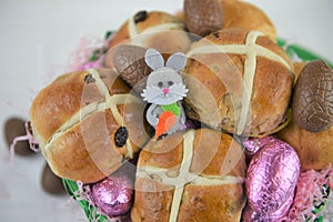 Closeup Easter food with fresh hot cross buns and cute bunny decoration