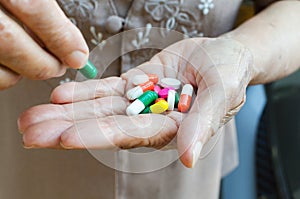 Closeup of an elderly hand holding pills