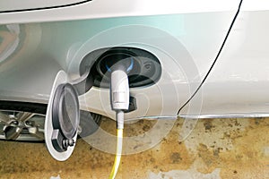 Closeup of electric hybrid car being charged with socket