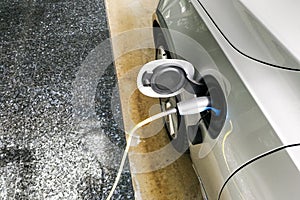 Closeup of electric hybrid car being charged with socket