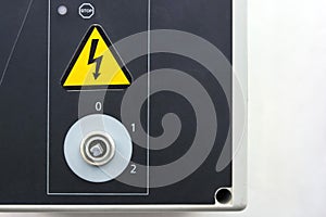 Closeup electrical board with knob and safety sign