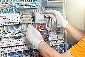 A closeup of an electrical engineer working in a power electrical panel