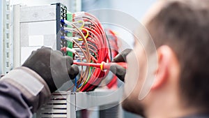 Closeup of electrician engineer works with electric cable wires