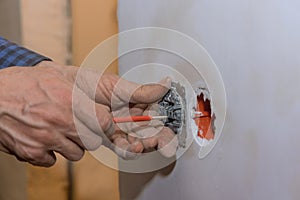 Closeup of electrician hands installing wall socket