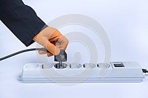 Closeup of electrician plugging extension cords into each other. Womanâ€™s hand plugging extension cord, white background