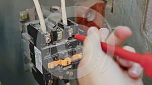 Closeup. Electricians hands testing current electric in control panel. Electrician engineer work tester measuring