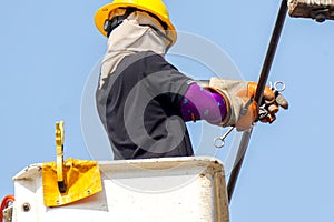 Closeup Electricians working to repair the power line under light blue sky background