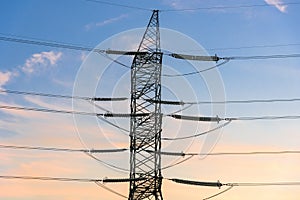 Closeup of electricity pylon and lines at sunset