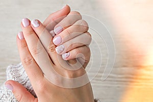 Closeup elegant pastel natural modern design manicure. Female hands. Gel nails. Nude manicure. Beige color. Skin care
