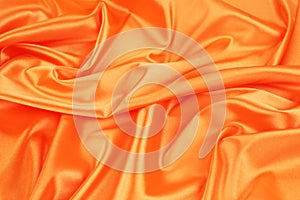 Closeup of elegant shiny orange silk background.