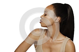 Closeup of an elegant young Black woman posing profile with long straight hair and ponytail