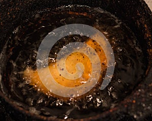 Closeup of empanada deep fried in a pot