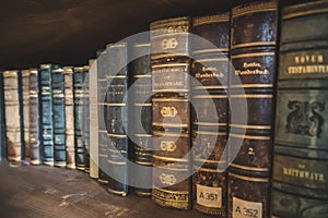 Closeup of encyclopedias and books in the library shelf arranged with one line