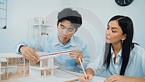 Closeup of engineer team working together to measure house model. Immaculate.